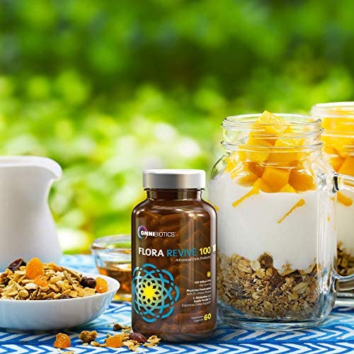 A jar of granola next to an Omnibiotics Flora Revive supplement bottle on a wooden surface.